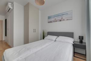 una camera da letto bianca con un letto grande di Trimare Seaside Apartment a Sztutowo