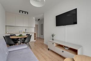 una cucina e un soggiorno con tavolo e TV di Trimare Seaside Apartment a Sztutowo