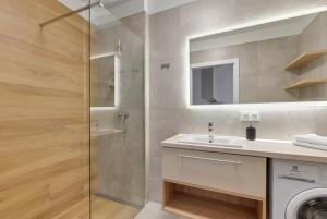 bagno con doccia, lavandino e lavatrice di Trimare Seaside Apartment a Sztutowo Altre 11 foto