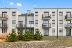 un grande edificio con balconi e alberi di fronte di Trimare Seaside Apartment a Sztutowo