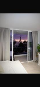 ein Schlafzimmer mit Bett und Balkon mit Aussicht in der Unterkunft ¡Tal y como Hawaii! in Playa Fañabe