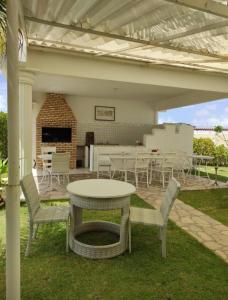 a patio with a table and chairs and a fireplace at Apartamento 218, primeiro andar, Canoa Quebrada in Aracati
