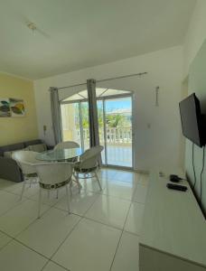 a living room with a glass table and chairs at Apartamento 218, primeiro andar, Canoa Quebrada in Aracati