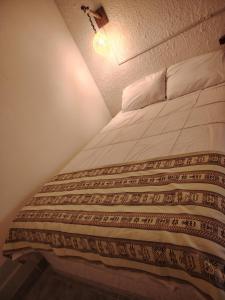 Bett in einem kleinen Zimmer mit in der Unterkunft Cabañas SAL Y PIEDRA in Uyuni