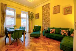 a living room with a green couch and a table at Karlsbad Promenade Apartment in Karlovy Vary