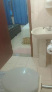 a bathroom with a toilet and a sink at Hospedaria Meu lar 2 in Rio das Ostras