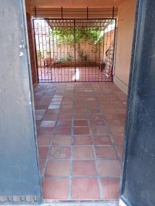 an open door with a gate with a cat inside at Posada domiciliar DB in São Gabriel +11 photos