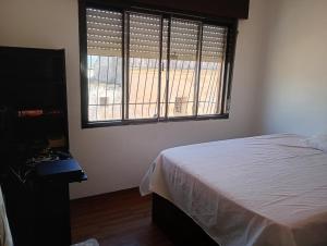 a bedroom with a bed and a large window at Posada domiciliar DB in São Gabriel