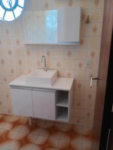 a bathroom with a white sink and a window at Posada domiciliar DB in São Gabriel