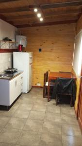 una cucina con un tavolo e un frigorifero bianco di Cabaña El Atardecer 2 a Necochea