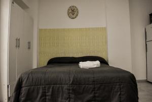 a bedroom with a bed with a clock on the wall at Loft Rio - Ideal turismo - Opcion a cochera! in Rosario