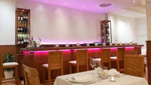 ポリフロノにあるAkrogiali Exclusive Hotel (Adults Only)のピンクの照明が施されたバー付きのレストラン