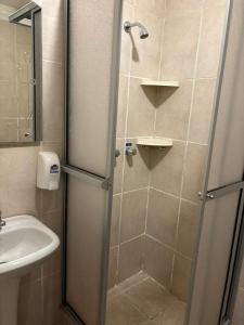 a shower with a glass door next to a sink at Hostal Distrito in Sucre +49 photos