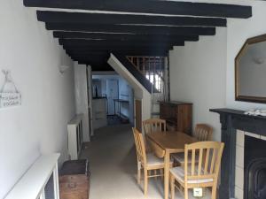 a dining room with a table and chairs and a fireplace at Neifion in Aberdyfi +3 photos