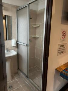 une salle de bain avec douche et lavabo dans l'établissement Centro Cultural Distrito, à Sucre