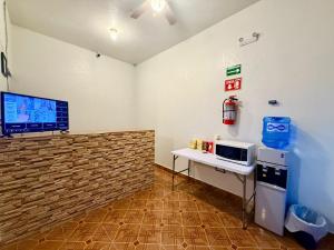 a room with a microwave and a table with a microwave at Comod Inn in Manuel F. Martínez