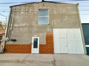 a building with a white door and a fence at Comod Inn in Manuel F. Martínez