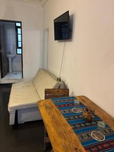 une chambre avec un lit et une télévision au mur dans l'établissement Centro Cultural Distrito, à Sucre
