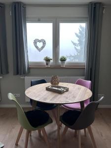 einen Tisch und Stühle in einem Zimmer mit einem Herzfenster in der Unterkunft Haus Martha - Top Modernes Apartment in der Natur in Willingen
