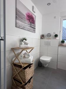 ein Badezimmer mit Toilette und einem rosa Baum in der Unterkunft Haus Martha - Top Modernes Apartment in der Natur in Willingen