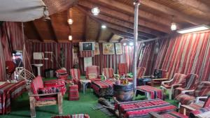 ein Wohnzimmer mit roten Stühlen und einem Kamin in der Unterkunft חאן לקיה in Kramim