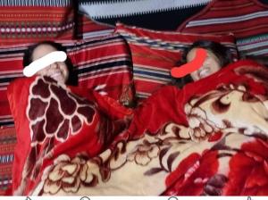 zwei Personen liegen mit einer Giraffe im Bett. in der Unterkunft חאן לקיה in Kramim