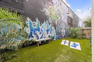 een muur met een bank voor een muurschildering bij Rooftop EaDo Nr Downtown Yard BBQ Games WiFi in Houston