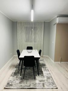 Un comedor con una mesa y sillas blancas. en City View Apartment, en Kosovska Mitrovica 5 fotos más