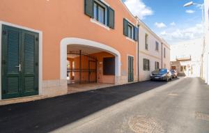 an orange building with a car parked next to a street at Lovely Apartment In Sant'antioco With Wifi in SantʼAntìoco