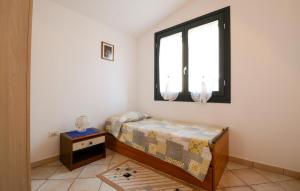 a small bedroom with a bed and a window at Lovely Apartment In Sant'antioco With Wifi in SantʼAntìoco