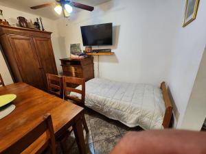 een kleine kamer met een bed en een tv bij Casa Vizcaino in Ensenada