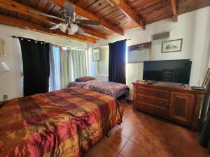 een slaapkamer met een bed en een flatscreen-tv bij Casa Vizcaino in Ensenada