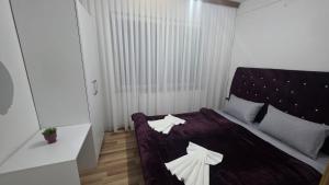 ein Schlafzimmer mit einem lila Bett und weißen Kissen in der Unterkunft Apartment Gostivar in Gostivar