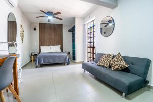 een woonkamer met een bank en een bed bij Peach35L Céntrico studio super ubicado y tranquilo in Cancun
