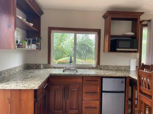 uma cozinha com pia e janela em K S G Cabanas em Dangriga mais 13 fotografias
