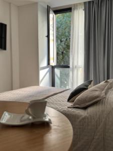 een kamer met een bed, een tafel en een raam bij Brooklyn Suites MDP in Mar del Plata