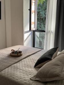 een bed met een klok erop met een raam bij Brooklyn Suites MDP in Mar del Plata