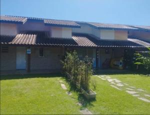a house with a lawn in front of it at Sarau's Beach House Boracéia in Boracéia