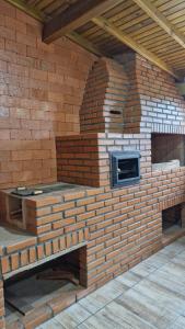 una pared de ladrillo con un horno de ladrillo en ella en Suíte família SOL & LUA Guarda do Embaú SC, en Guarda do Embaú