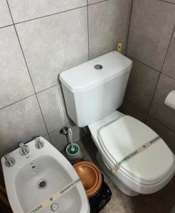 a bathroom with a white toilet and a sink at Edificio Meraki 2 in Victoria +8 photos