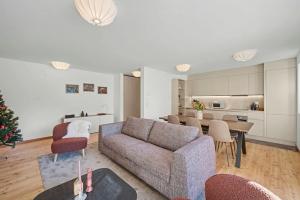 ein Wohnzimmer mit Couch und ein Esszimmer in der Unterkunft Comfort and space for families, 3 bedrooms and garden in Arni Alp