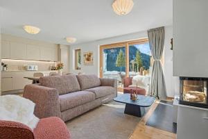ein Wohnzimmer mit Couch und Tisch und eine Küche in der Unterkunft Comfort and space for families, 3 bedrooms and garden in Arni Alp