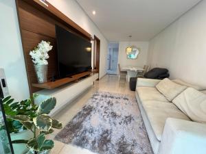un soggiorno con divano e grande TV a schermo piatto di Casa Tranquila a Vitória