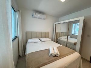 una camera con due letti, asciugamani e specchio di Casa Tranquila a Vitória