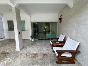 un soggiorno con 2 sedie e una parete di vetro di Casa Tranquila a Vitória