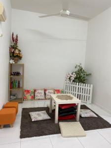 a living room with a table and a chair at Bukit Katil Indah Homestay in Melaka