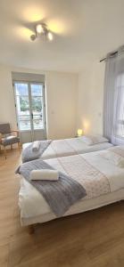 two beds in a bedroom with a window at Le Charme du Sanctuaire 8 couchages 400m de la Grotte in Lourdes