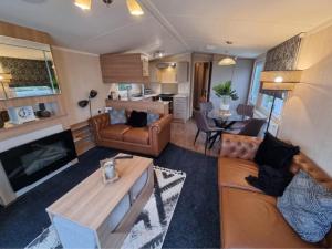 een woonkamer met een bank en een tafel bij Leas Happy Haven in Goswick Station