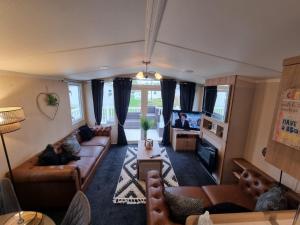 een woonkamer met een bank en een tv bij Leas Happy Haven in Goswick Station