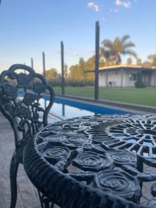 a black bench with roses on it next to a pool at Complejo Bohio Hotel Boutique in Lobos